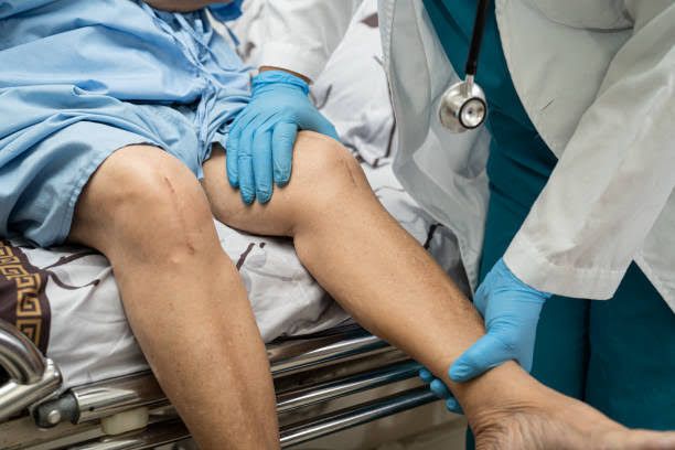 Medical professional examining patient's knee